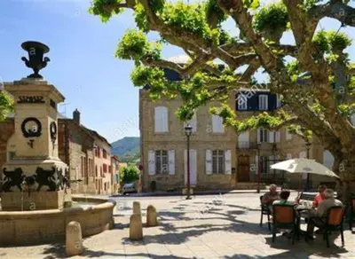 a group of people sitting at a table next to a fountain at OCC34 - Capestang - Manoir in Capestang